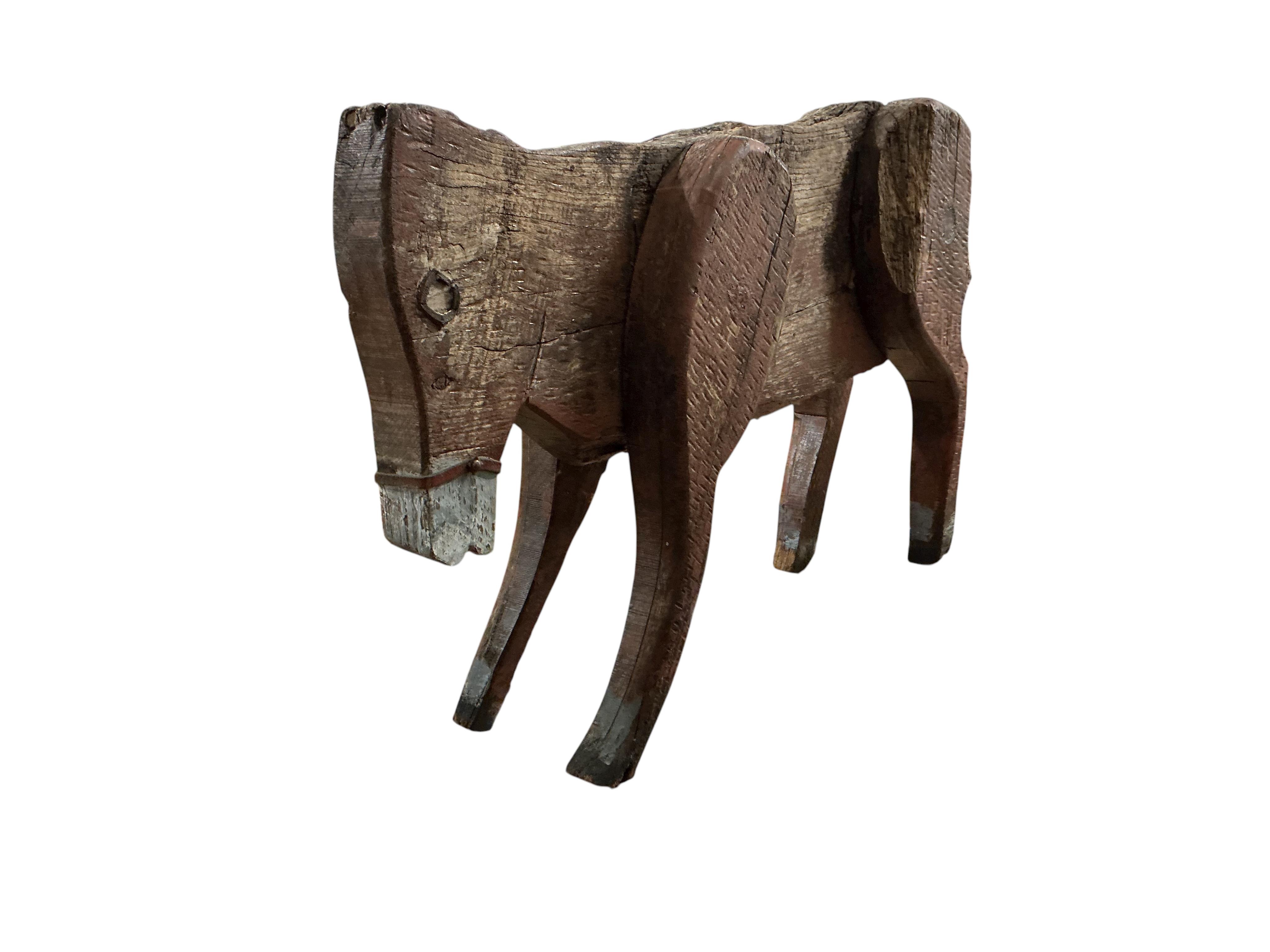 A 19th century primitive painted wood model of a cow with articulated limbs, length 100cm, height 62cm